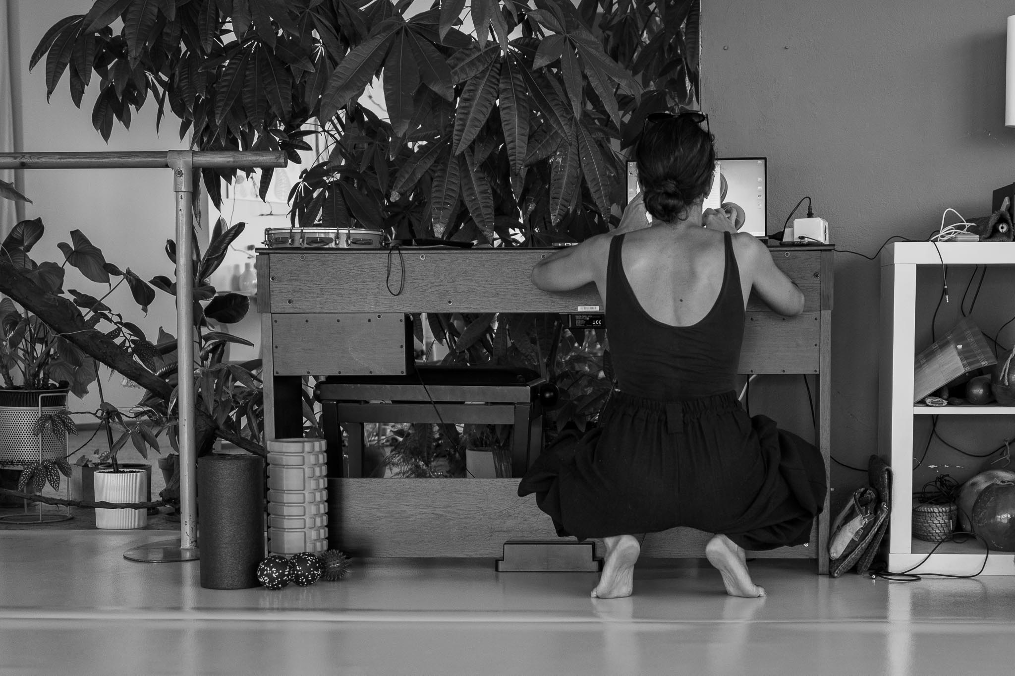 Vilelmini crouching in front of a desk, adjusting the workshop equipment.